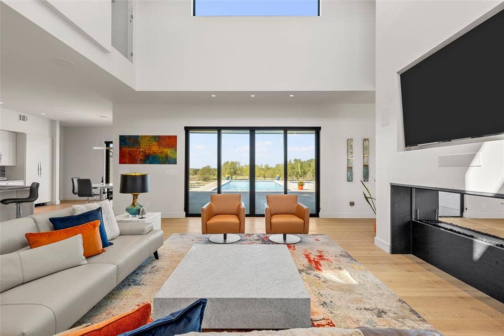 356 Bold Springs Court, West, TX 76691 Double-height ceilings with recessed lighting, floor-to-ceiling multi-panel sliding glass doors, built-in linear ethanol fireplace, and wood flooring