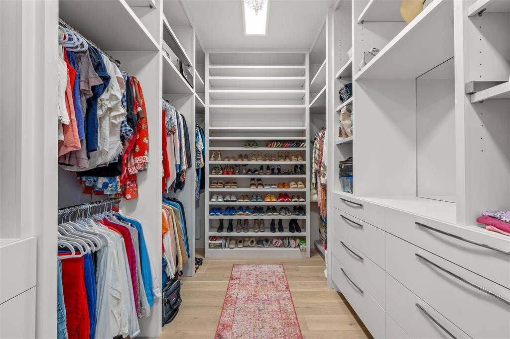 356 Bold Springs Court, West, TX 76691 Custom walk-in 2-sided closet featuring floor-to-ceiling white cabinetry, integrated open shelving, wood flooring, and recessed lighting. Chandelier is excluded from sale