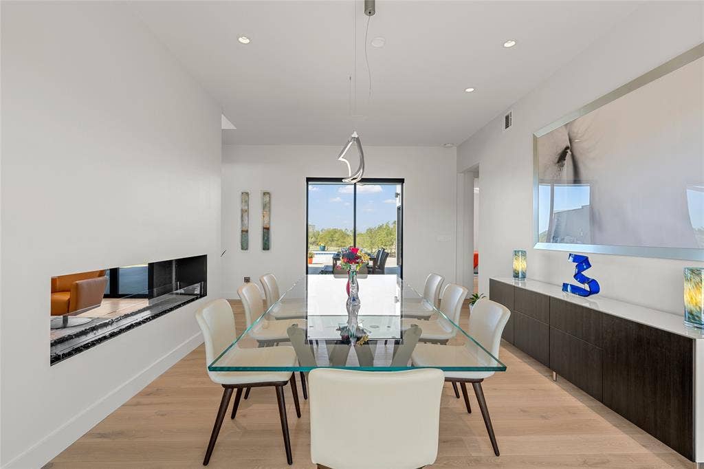 356 Bold Springs Court, West, TX 76691 Modern dining space featuring wood flooring, recessed lighting, a linear built-in fireplace, a suspended architectural light fixture, and expansive glass sliding doors