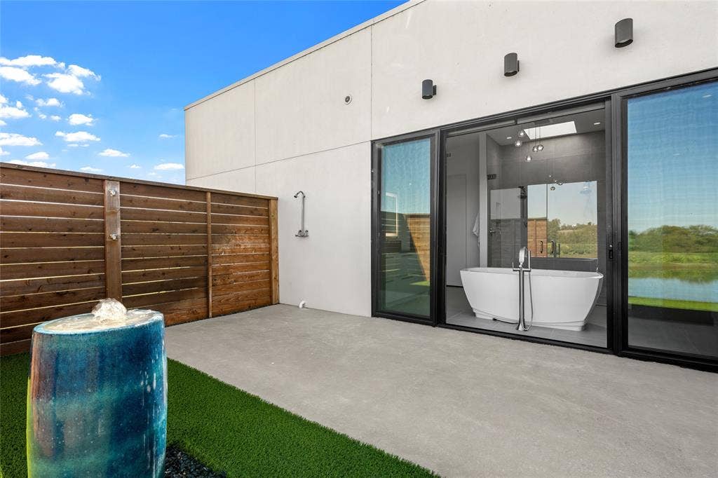 356 Bold Springs Court, West, TX 76691 Private patio featuring concrete flooring, a horizontal wood privacy fence, a built-in outdoor shower, and a decorative ceramic water feature