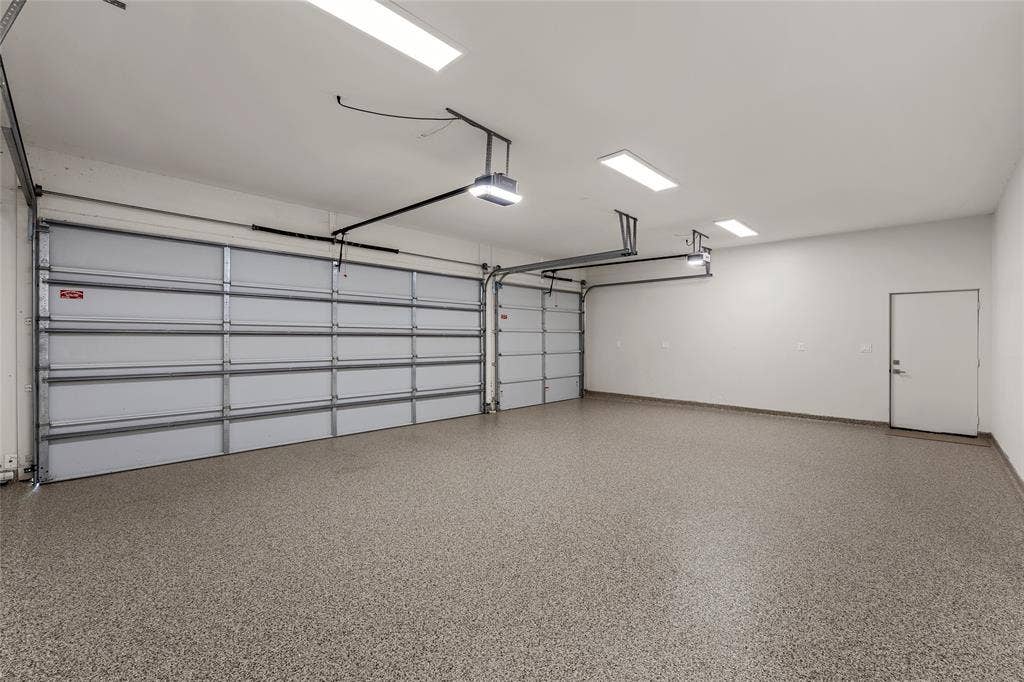 356 Bold Springs Court, West, TX 76691 Solar ready Three-car attached garage featuring epoxy-coated flooring, dual overhead app and wifi enabled door systems, EV ready, high-output flush-mount lighting, and a separate pedestrian entry door and a large climate controlled storage area