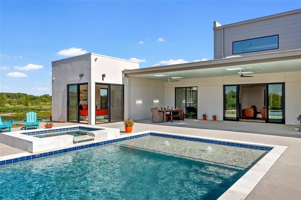 356 Bold Springs Court, West, TX 76691 Modern exterior featuring a covered concrete patio, integrated pool and spa with tile detailing, and floor-to-ceiling glass sliding doors