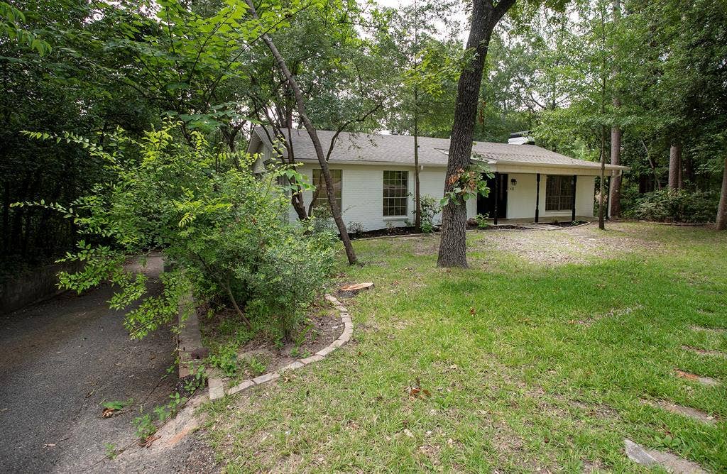 431 Lone Star Lane, Hideaway, TX 75771 Single-story home exterior featuring a white painted brick facade, covered front porch with support pillars, and asphalt driveway
