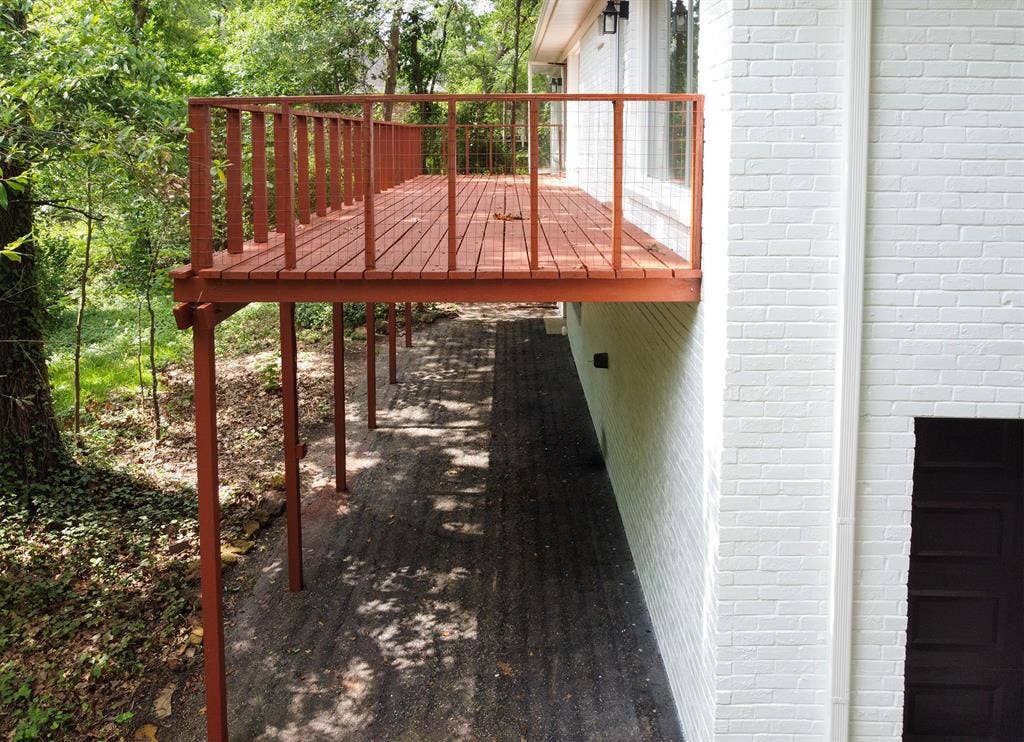 431 Lone Star Lane, Hideaway, TX 75771 Elevated wooden deck featuring a railing, white painted brick exterior, and a lower-level paved patio area