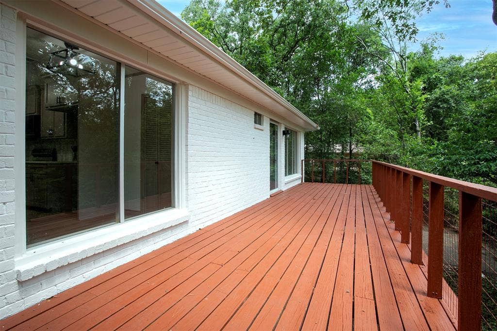 431 Lone Star Lane, Hideaway, TX 75771 Painted brick exterior featuring an expansive wood deck with metal cable railing and sliding glass doors