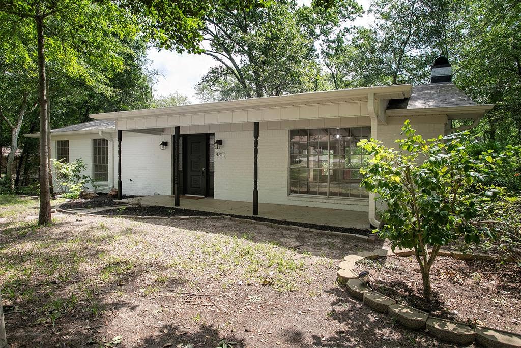 431 Lone Star Lane, Hideaway, TX 75771 Painted brick exterior featuring a covered front porch, decorative pillars, large multi-pane windows, and a chimney