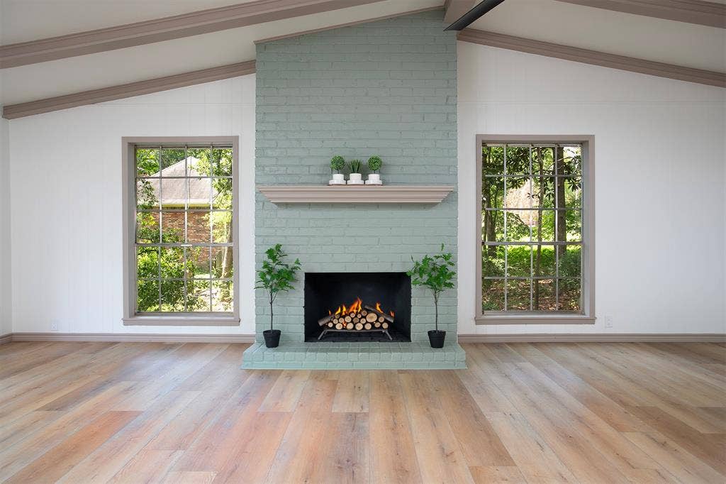 431 Lone Star Lane, Hideaway, TX 75771 Vaulted ceiling with exposed beams, painted brick fireplace with mantle, wood-finish flooring, and large multi-pane windows