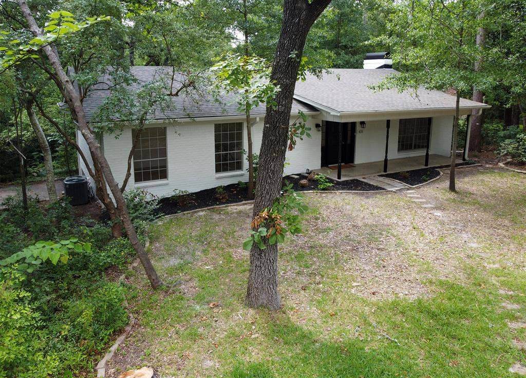 431 Lone Star Lane, Hideaway, TX 75771 Single-story exterior featuring a white painted brick facade, covered front porch, asphalt shingle roof, chimney, and multi-pane windows