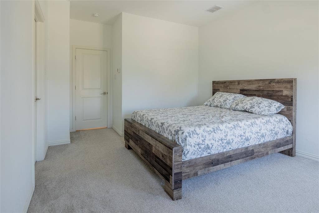 Neutral-toned carpeting, crisp white walls, and a multi-panel interior door