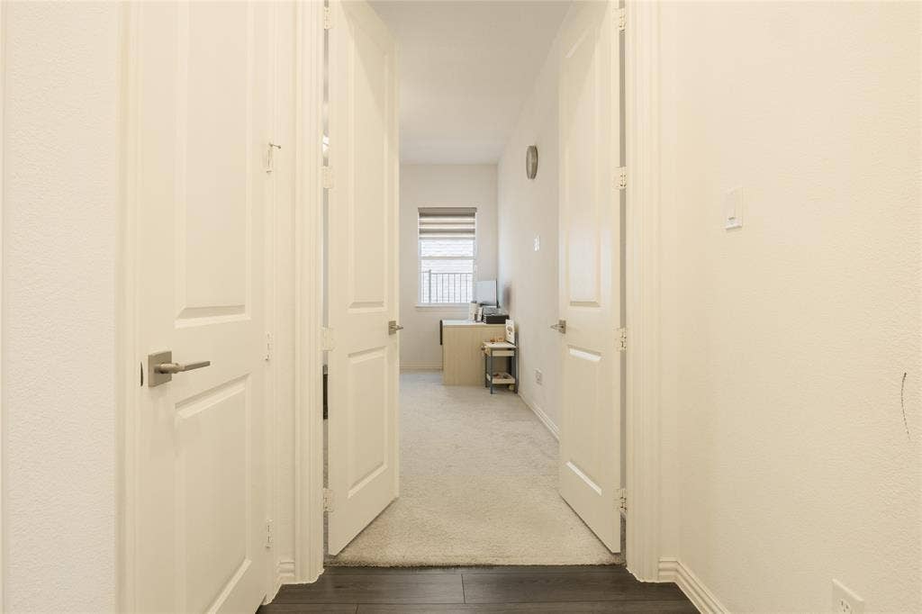 Double-panel swinging doors with satin-nickel lever hardware, neutral wall-to-wall carpeting, and wood-finish flooring