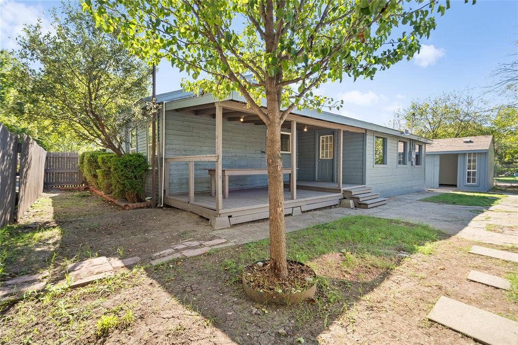 2005 Tisinger Avenue, Dallas, TX 75228 Exterior backyard space featuring a covered wooden deck, detached storage structure, privacy fencing, and mature trees