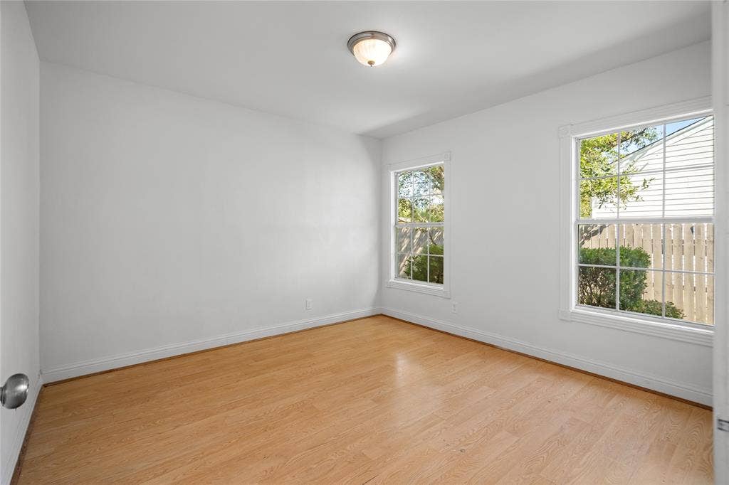 2005 Tisinger Avenue, Dallas, TX 75228 Neutral-toned room featuring wood-finish flooring, two dual-pane windows with muntins, and a central flush-mount ceiling light fixture