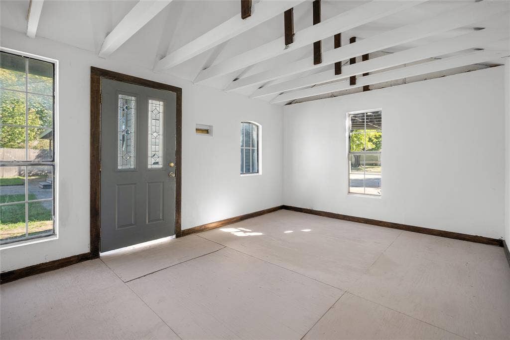 2005 Tisinger Avenue, Dallas, TX 75228 Interior space featuring exposed white-painted rafters, multiple windows with grid detailing, and an exterior door with decorative glass panes