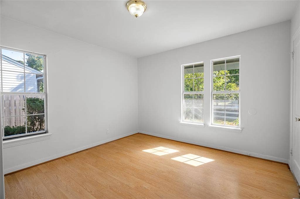 2005 Tisinger Avenue, Dallas, TX 75228 Interior space featuring wood-finish flooring, white walls, dual-pane windows with muntins, and a flush-mount ceiling light fixture