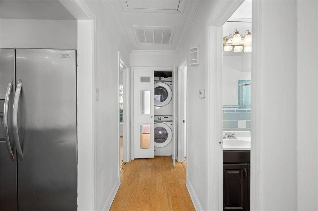 2005 Tisinger Avenue, Dallas, TX 75228 Stainless steel refrigerator, wood-finish flooring, stackable washer and dryer, glass-paneled closet door, and vanity with dark-finish cabinetry