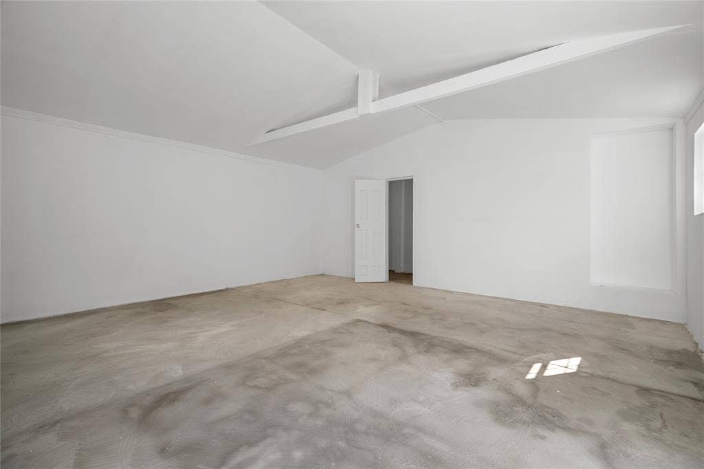 2005 Tisinger Avenue, Dallas, TX 75228 Interior space featuring vaulted ceilings, a structural support beam, concrete flooring, and a six-panel interior door
