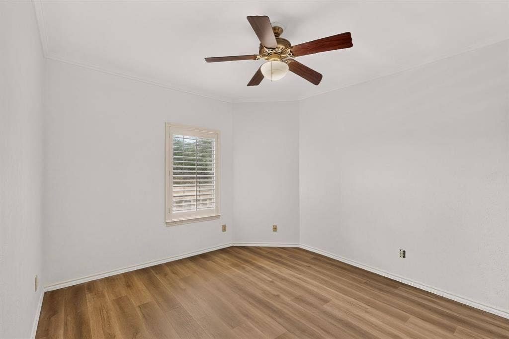Second bedroom featuring newly installed laminate flooring and fresh paint.