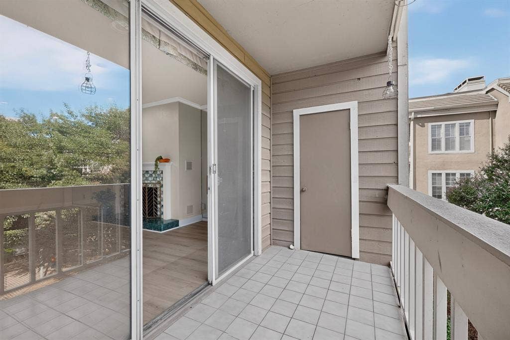 Relax on your private balcony featuring tiled flooring, decorative lighting and a dedicated storage closet accessible via a single-panel door.
