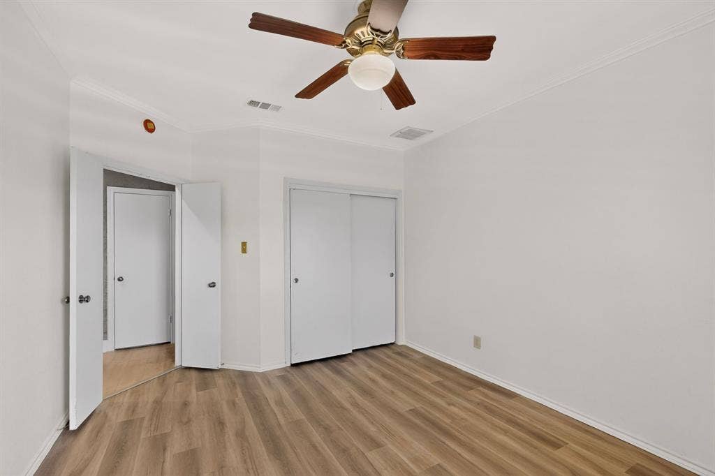 Fresh paint and newly installed flooring in the second bedroom with double sliding doors on the interior closet space.