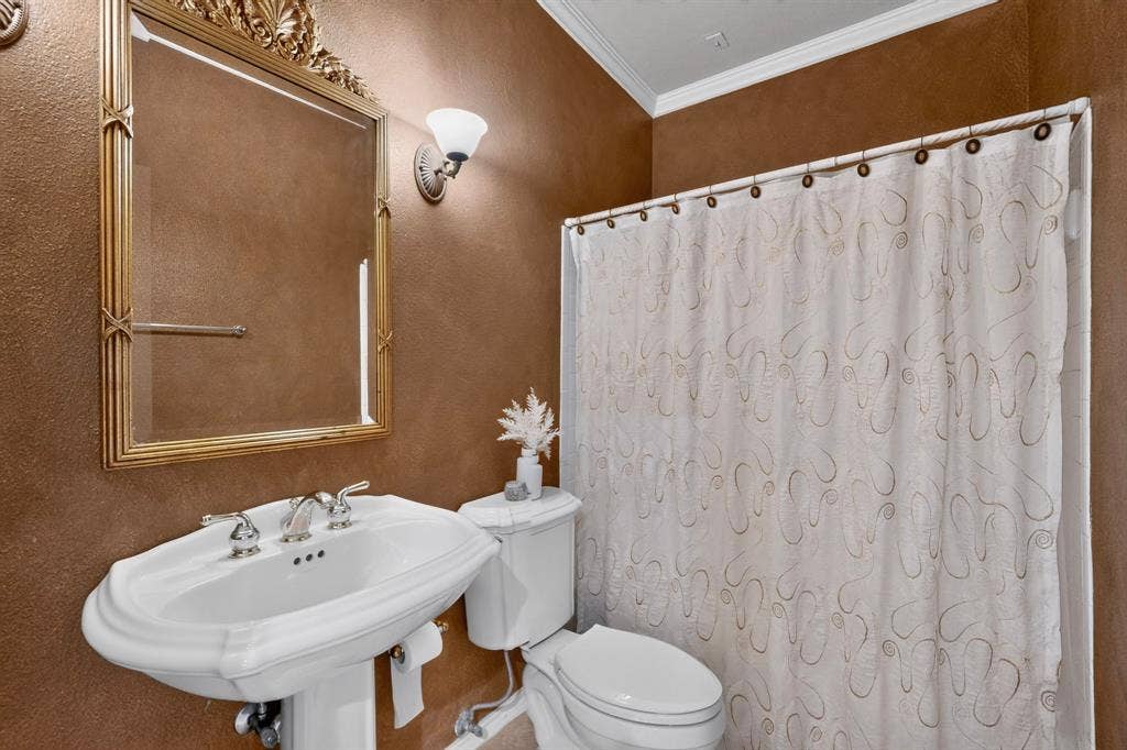 Mediterranean inspired four-piece bathroom featuring a pedestal sink, toilet, shower and soaking tub.