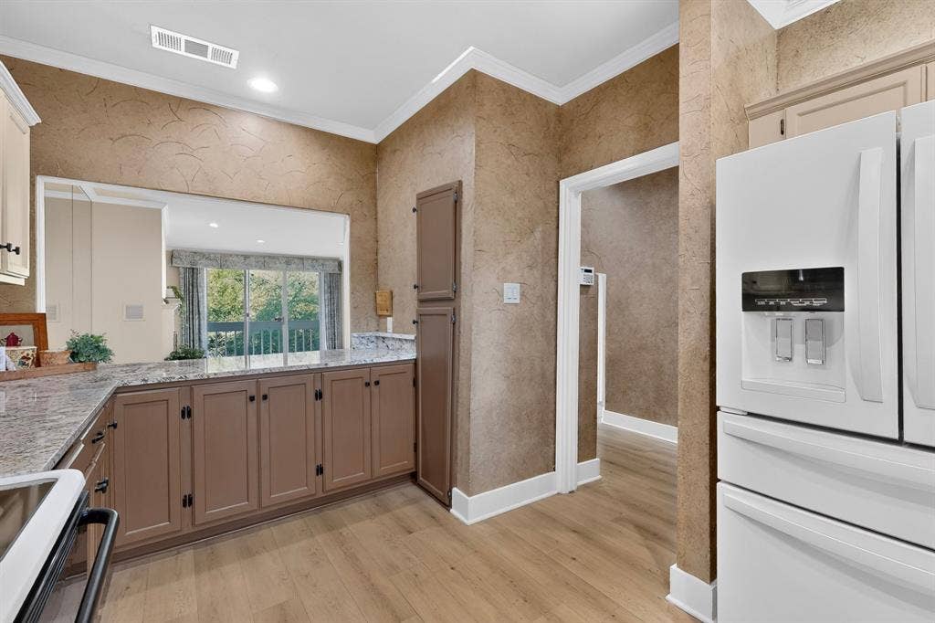 Plenty of natural light in this updated kitchen with breakfast bar and a full-height pantry cabinet.