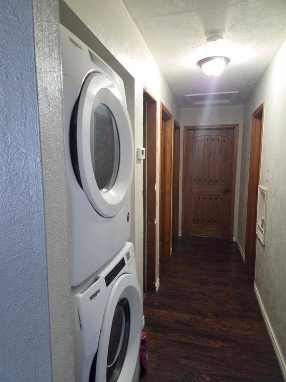 Stacked laundry unit, wood-finish flooring, and solid wood interior doors with decorative hardware