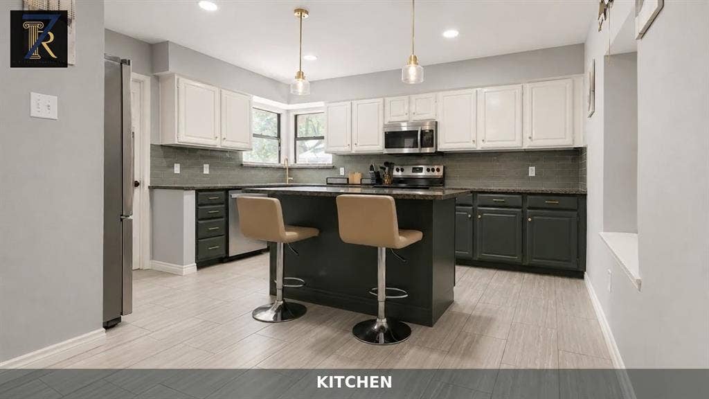 Kitchen featuring a center island, two-tone cabinetry, stainless steel appliances, tiled backsplash, and recessed lighting