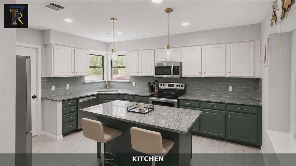 Kitchen featuring two-tone cabinetry, stone countertops, gray subway tile backsplash, stainless steel appliances, and a central island with pendant lighting