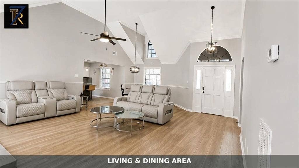 Vaulted ceilings, wood-finish flooring, arch-top windows, integrated ceiling fan, and pendant lighting