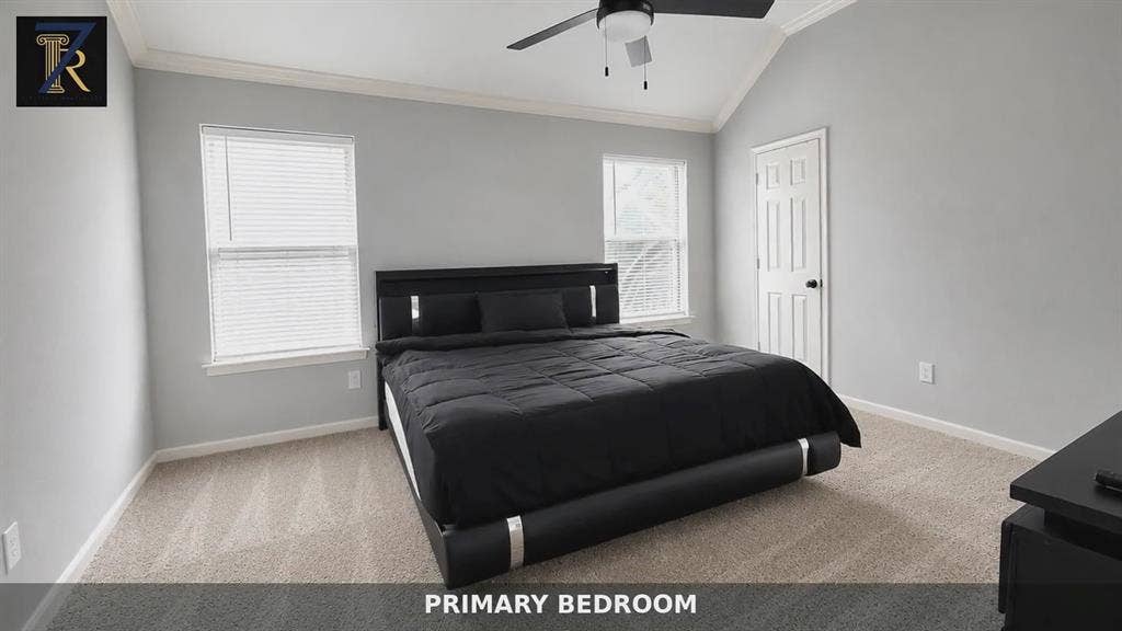 Vaulted ceilings featuring crown molding, neutral wall finishes, carpeted flooring, and a central ceiling fan