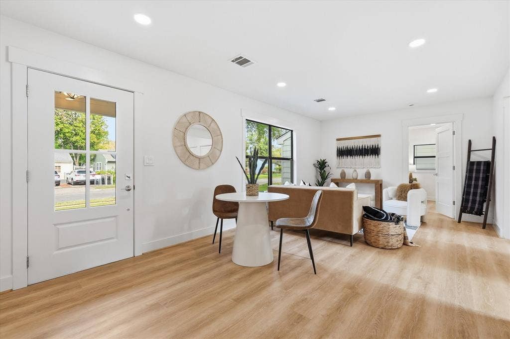 11624 Rupley Lane, Dallas, TX 75218 Open-concept area featuring light wood-finish flooring, recessed lighting, white four-panel door with glass inserts, and black-framed windows