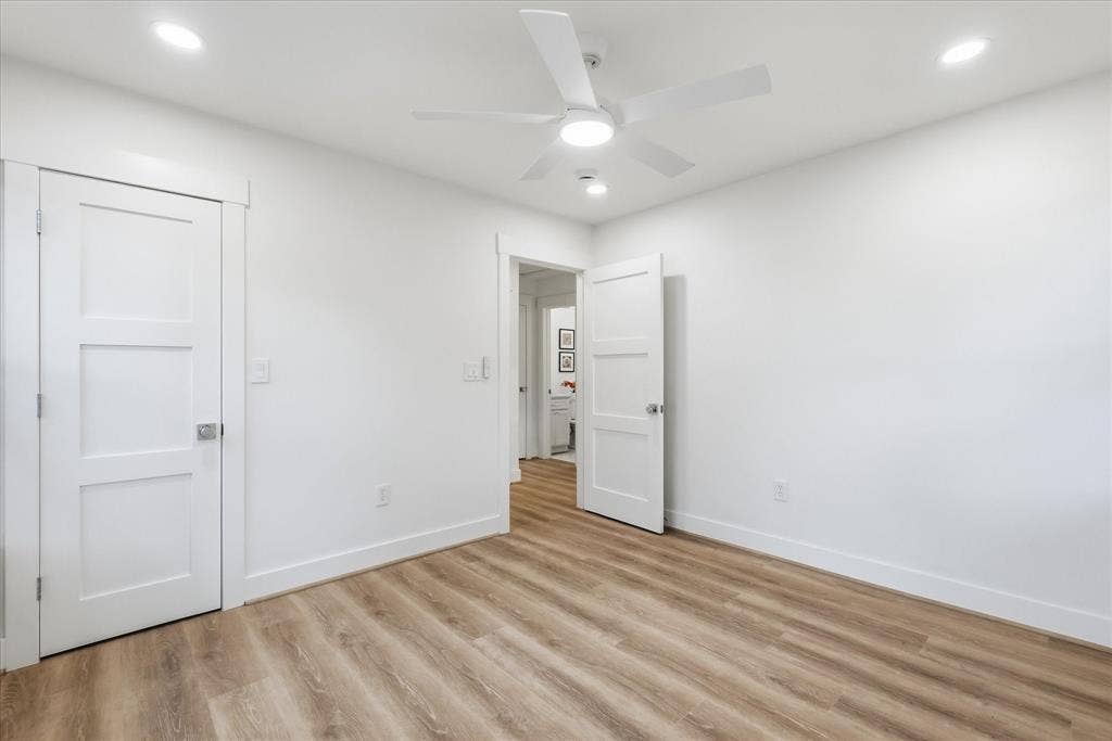 11624 Rupley Lane, Dallas, TX 75218 Wood-finish flooring, white three-panel interior doors, recessed lighting, and a modern white ceiling fan with integrated light