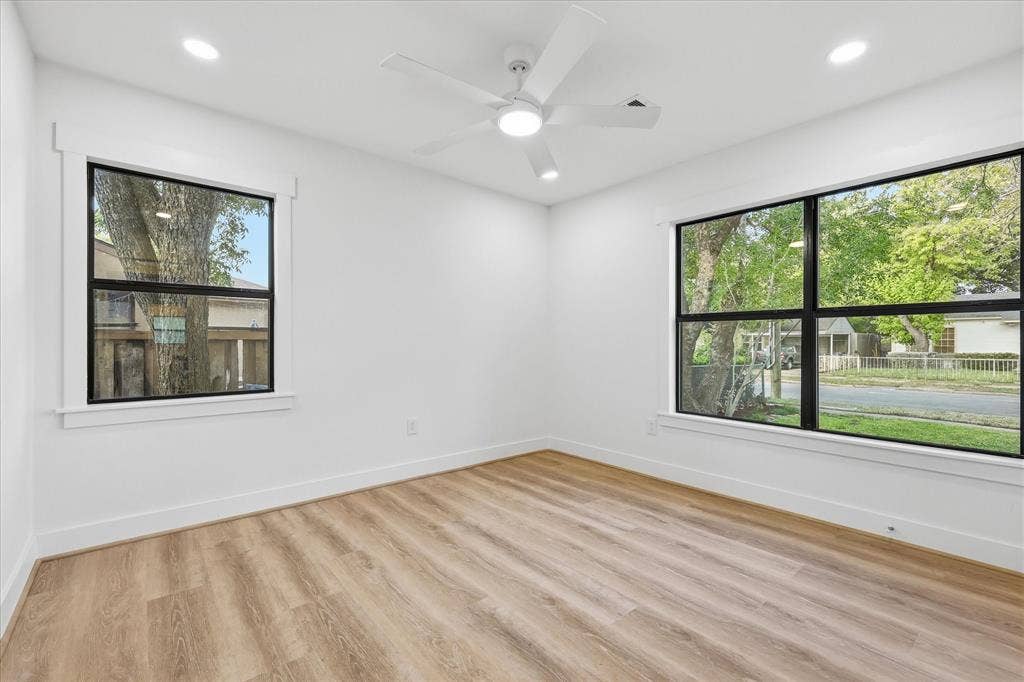 11624 Rupley Lane, Dallas, TX 75218 Neutral interior featuring wood-finish flooring, recessed lighting, a white ceiling fan, and large windows with black frames
