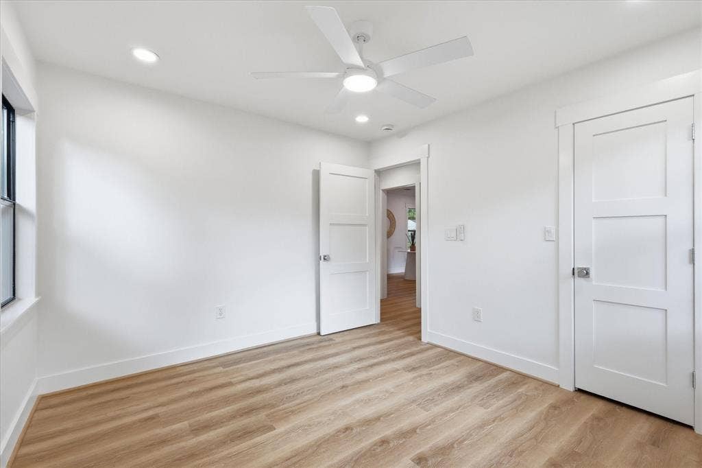 11624 Rupley Lane, Dallas, TX 75218 Neutral interior featuring wood-finish flooring, white three-panel doors, recessed lighting, and a modern ceiling fan with an integrated light fixture