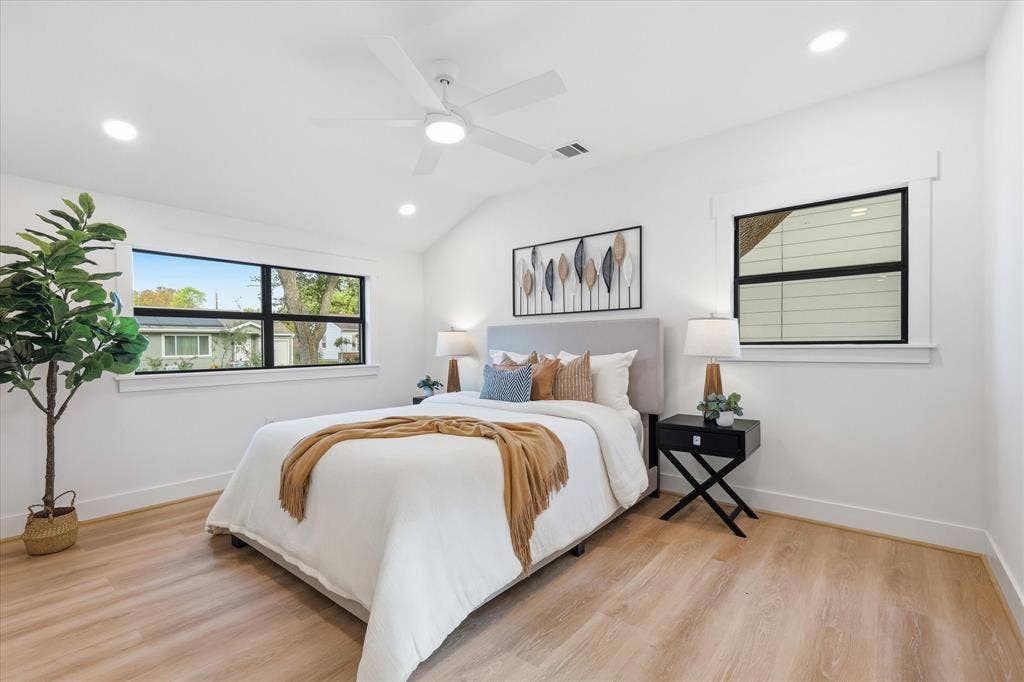 11624 Rupley Lane, Dallas, TX 75218 Bedroom featuring wood-finish flooring, vaulted ceilings, recessed lighting, a white ceiling fan, and windows with black frames