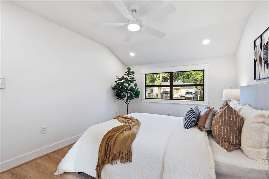 11624 Rupley Lane, Dallas, TX 75218 Vaulted ceiling with white ceiling fan, recessed lighting, wood-finish flooring, and large window with dark-frame trim