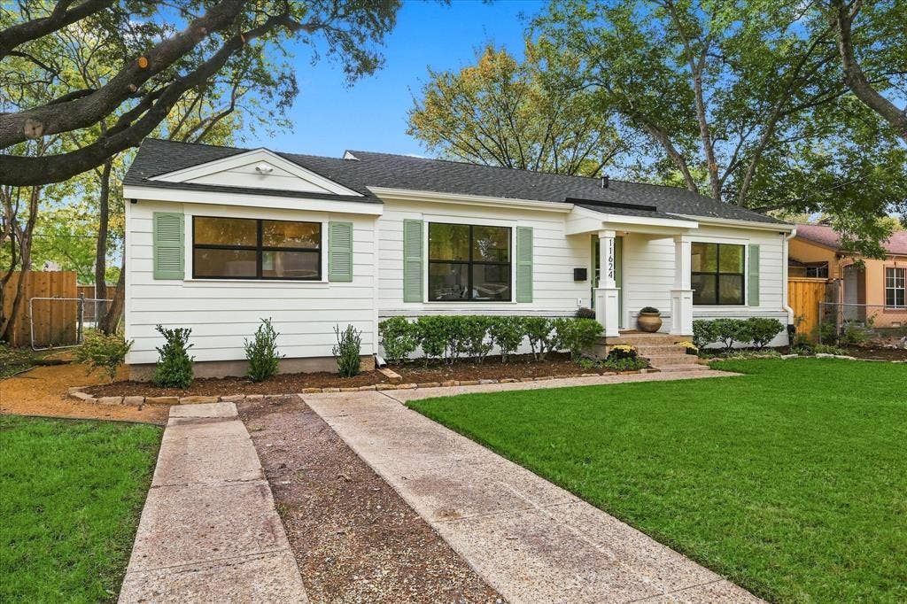 11624 Rupley Lane, Dallas, TX 75218 Traditional exterior featuring horizontal siding, green shutters, a covered front entryway with structural columns, and a double-lane paved driveway