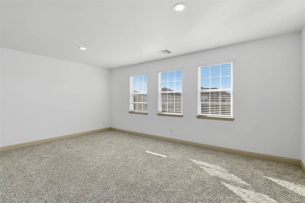 3125 Lucia Way, Princeton, TX 75407 Neutral-toned carpeted flooring, recessed lighting, and three double-hung windows