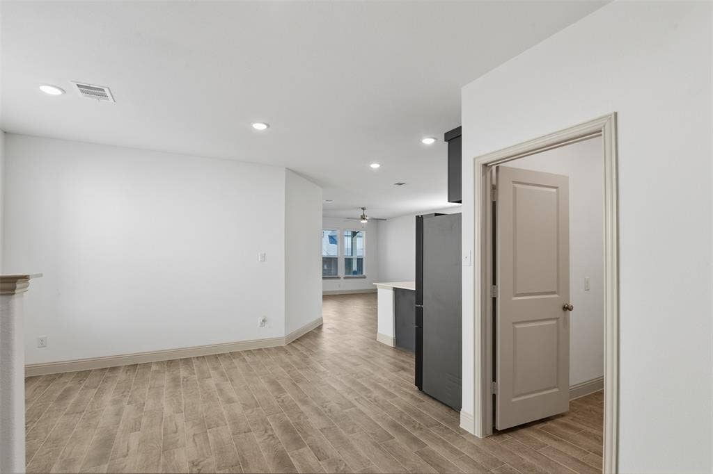 3125 Lucia Way, Princeton, TX 75407 Open floor plan featuring wood-finish flooring, recessed lighting, and a neutral color palette with a shaker-style interior door