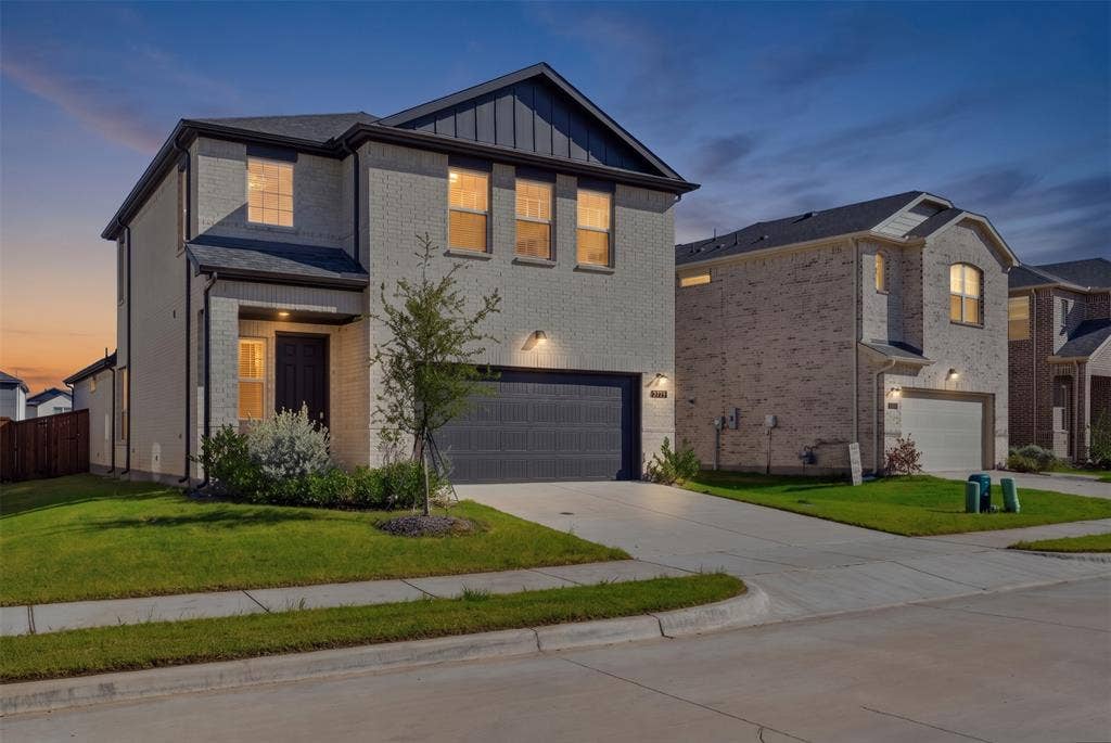 3125 Lucia Way, Princeton, TX 75407 Two-story exterior featuring light-toned brick masonry, vertical metal paneling accents, and a two-car garage