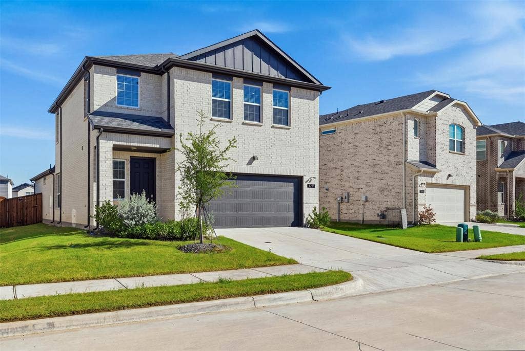 3125 Lucia Way, Princeton, TX 75407 Two-story brick exterior featuring a metal roof gable, vertical siding accents, and an attached two-car garage