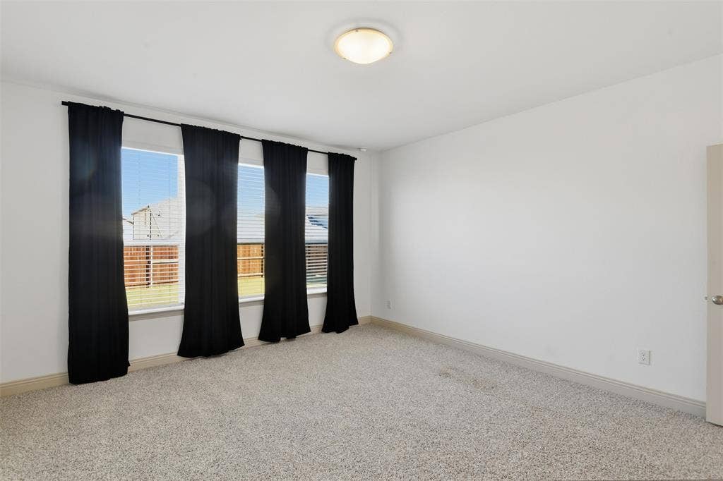 3125 Lucia Way, Princeton, TX 75407 Neutral-toned carpeted flooring, expansive windows with horizontal blinds, and a centrally mounted flush-mount ceiling light fixture