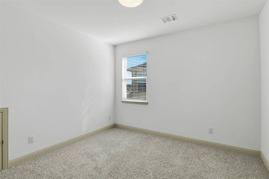 3125 Lucia Way, Princeton, TX 75407 Neutral interior space featuring crisp white walls, neutral-toned wall-to-wall carpeting, and a single-hung window with horizontal blinds