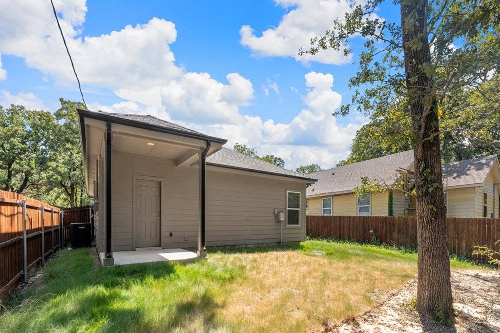 6144 Shawnee Drive, Mabank, TX 75156 Rear exterior featuring a covered concrete patio, horizontal siding, and a wooden perimeter fence
