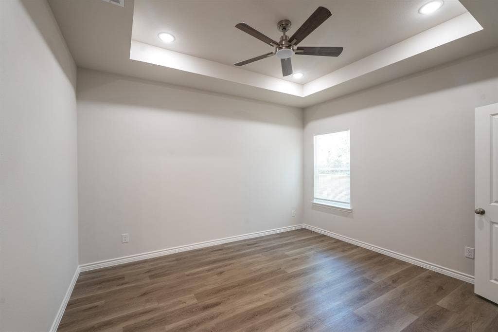 6144 Shawnee Drive, Mabank, TX 75156 Tray ceiling featuring a brushed nickel ceiling fan, recessed lighting, and wood-finish flooring