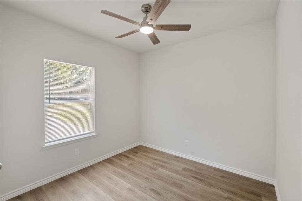 6144 Shawnee Drive, Mabank, TX 75156 Neutral-toned interior space featuring wood-finish flooring, a ceiling fan with integrated lighting, and a single-pane window