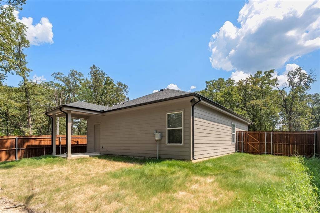 6144 Shawnee Drive, Mabank, TX 75156 Rear exterior featuring horizontal lap siding, a covered porch, and a wood privacy fence