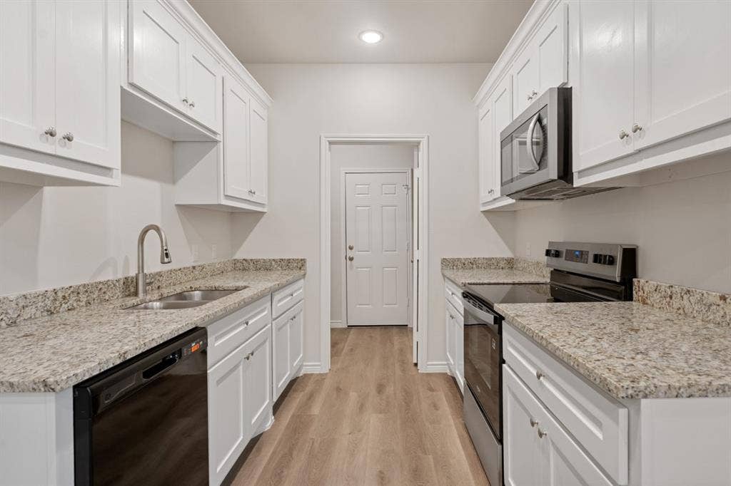 6144 Shawnee Drive, Mabank, TX 75156 Kitchen featuring white Shaker-style cabinetry, stone-finish countertops, stainless steel appliances, and wood-finish flooring
