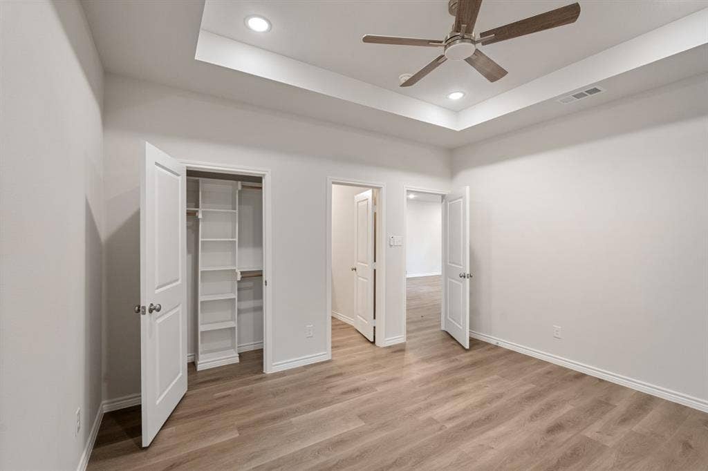 6144 Shawnee Drive, Mabank, TX 75156 Tray ceiling with recessed lighting, wood-finish flooring, ceiling fan, and built-in closet shelving