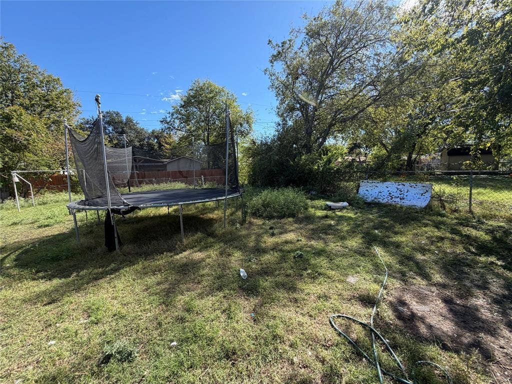 Backyard featuring mature trees and chain-link fencing